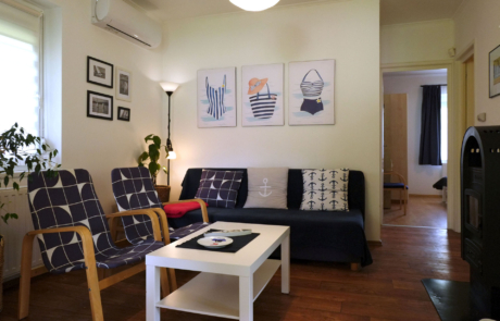 Cozy living room with navy and white patterned armchairs, a dark sofa, and a white coffee table on a wooden floor